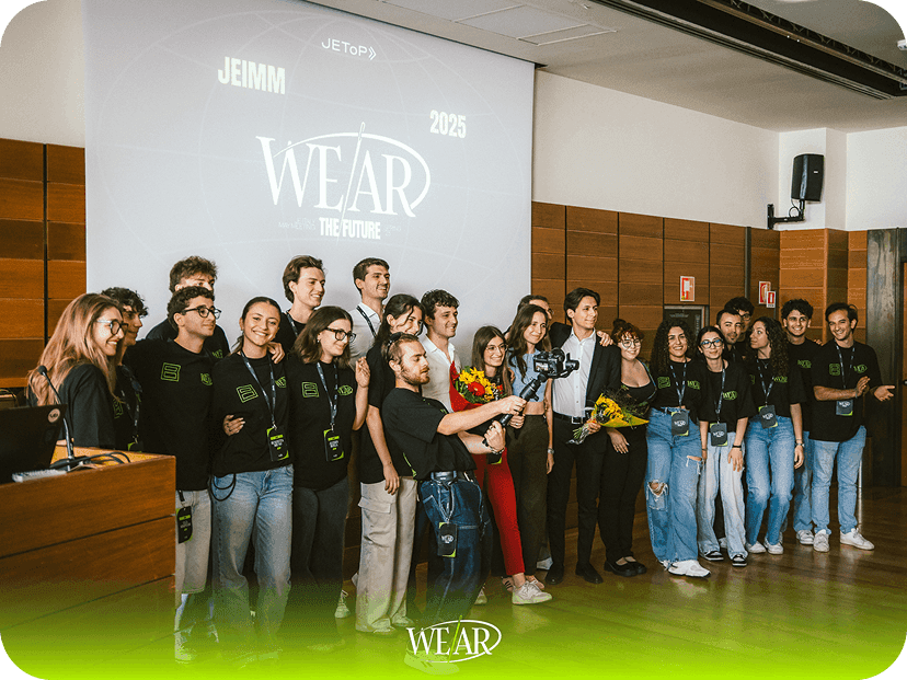 Group of event staff posing together on stage under the main screen