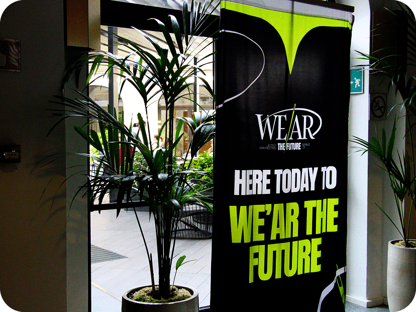 Event promotional roll-up banner reading Here today to we'ar the future