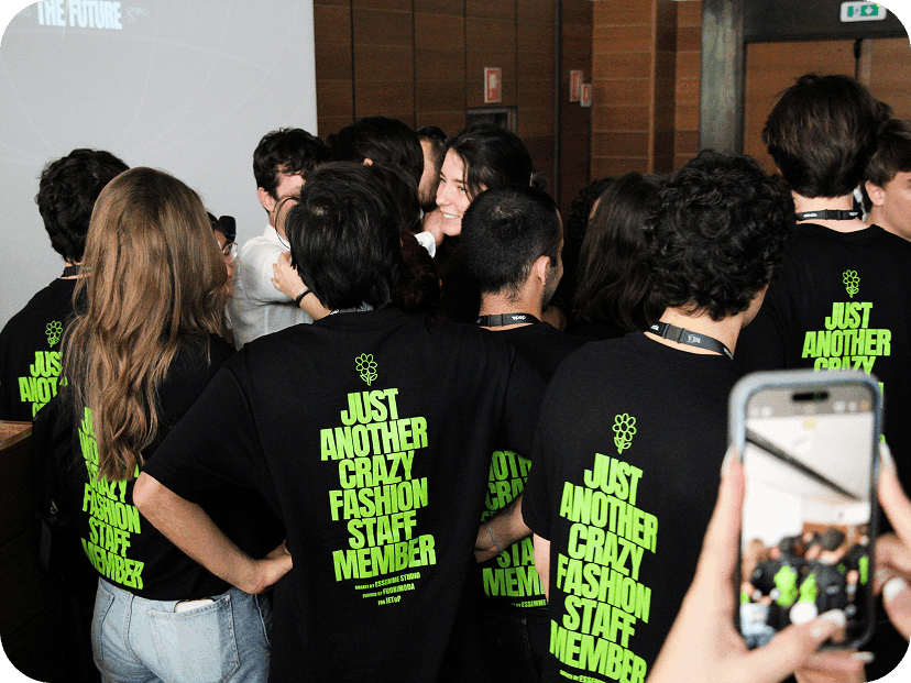 Group of event staff posing together on stage under the main screen